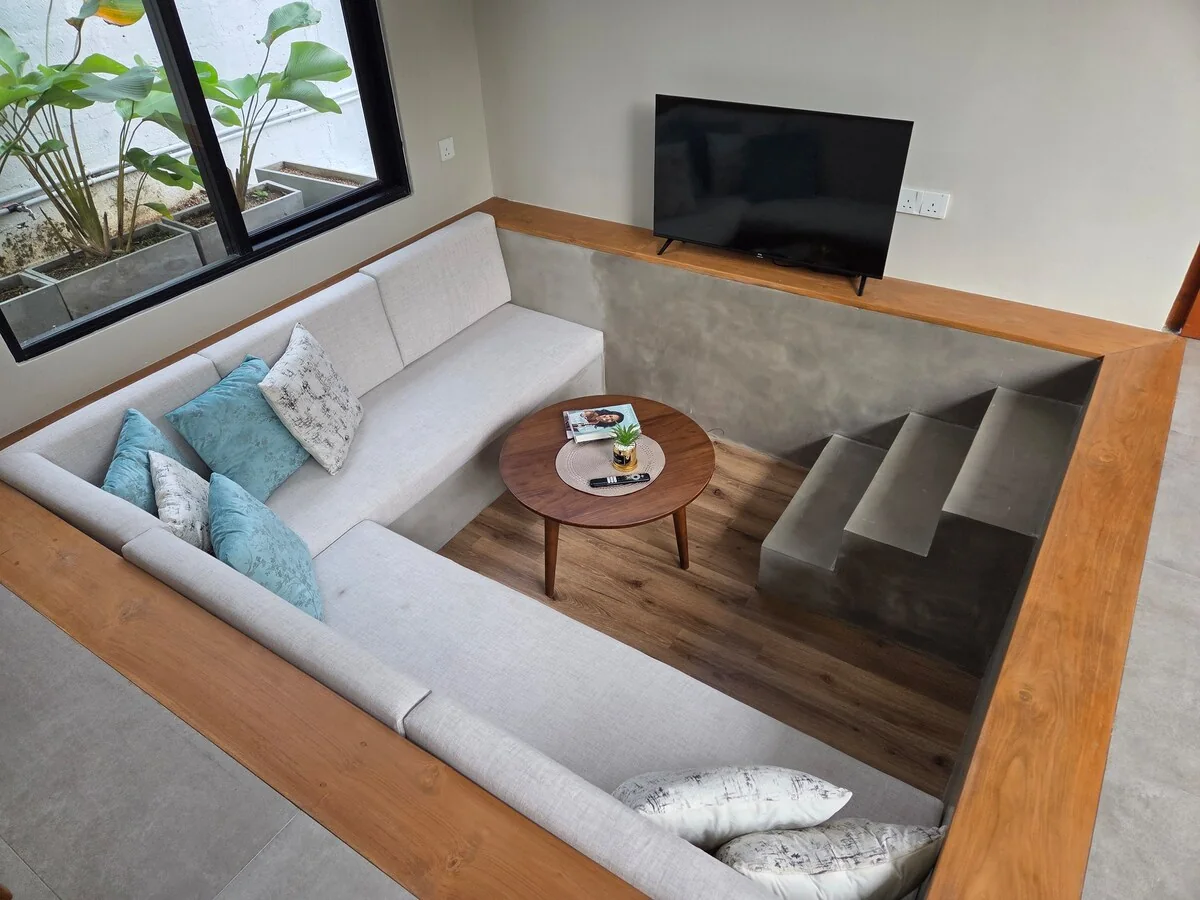 Sunken living area with sofa and television